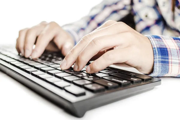 Frau im karierten Hemd schreibt auf eine schwarze Tastatur — Stockfoto