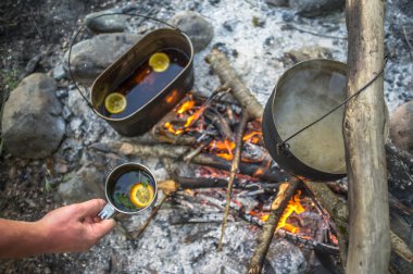 metal kupa çay, nane ve limon ile tutan adam