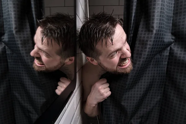 Hombre mojado mira desde detrás de una cortina de ducha, mira mal a alguien y se desnuda los dientes. — Foto de Stock