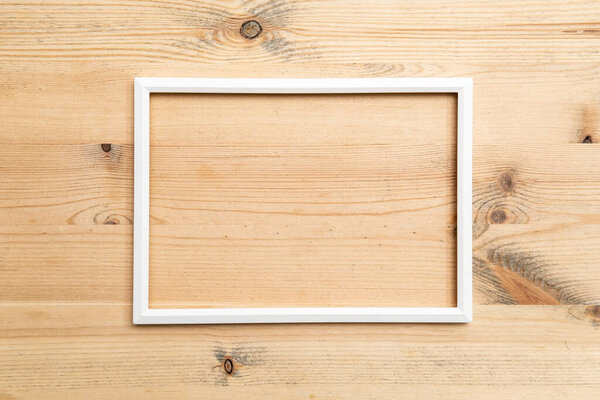 Rectangular blank white frame on wood texture. Abstract background. Copy space. Top view.