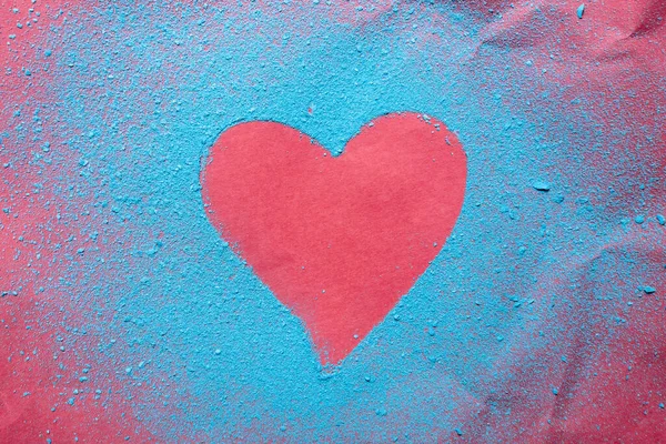 День Святого Валентина. Красное сердце - символ любви, посыпанный ярко-синим порошком, на ярком текстурированном фоне. Романтическая концепция.. — стоковое фото