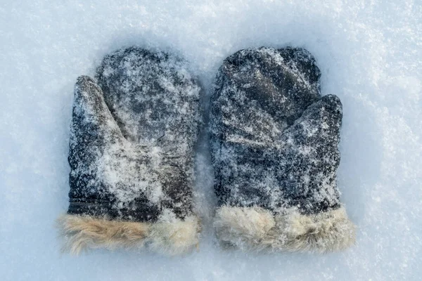 Snow-covered retro mittens, suede with natural fur on the snow, on a frosty winter day. Top view. — Stockfoto