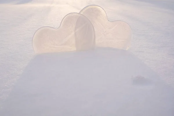 Two hearts - a symbol of love, made of ice, in the snow, in the rays of the sun. Valentines Day. Romantic concept. Copy space. — стоковое фото