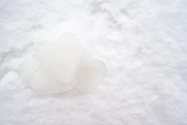 Pile of hearts - a symbol of love, made of ice, lie on the snow. Valentines Day. Romantic concept. Copy space. — Stock Photo, Image