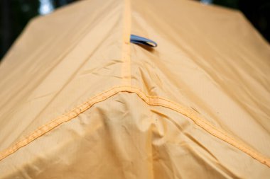 Su geçirmez turuncu çadır, yaz günü kamp yapmak. Aktif yaşam tarzı ve turizm. Yakın plan.. 