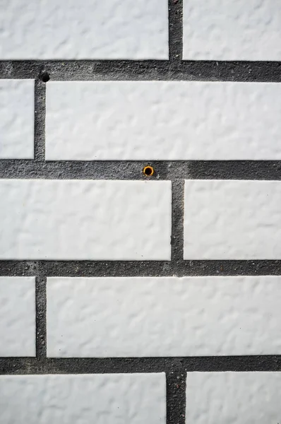 Текстурований фон. Стіна будинку акуратно оброблена плиткою, яка виглядає як біла цегла. Копіювати простір . — стокове фото