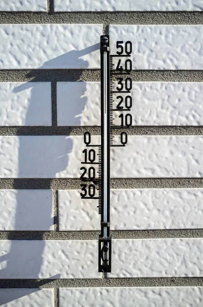 Thermometer zur Bestimmung der Lufttemperatur an einer Ziegelwand in den Sonnenstrahlen. — Stockfoto