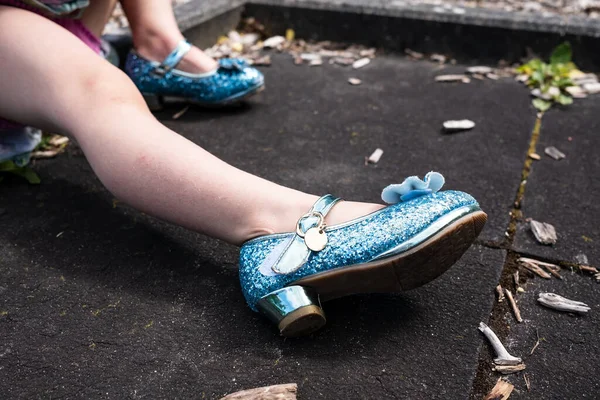 Jambes d'un enfant en belles chaussures à talons hauts bleu brillant, à l'extérieur. — Photo