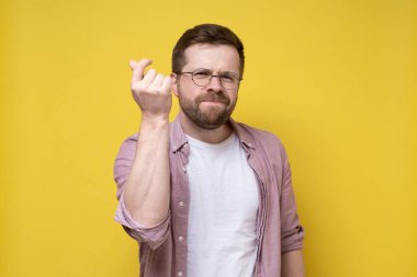 Becerikli adam soruna bir çözüm buldu, tatmin edici bir şekilde parmaklarını şaklattı ve kameraya baktı. İzole edilmiş, sarı arkaplan.