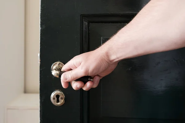 Male Hand Wants Close Black Wooden Door Holding Metal Handle — Stock Photo, Image