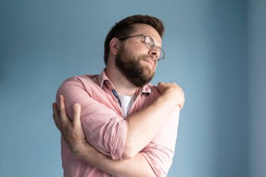 Yalnız, gözlüklü ve pembe gömlekli bir adamın hayalini kuruyor. Nazikçe kendine sarılıyor, gözlerini kapıyor, mavi arka planda duruyor..