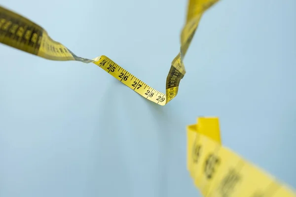 センチメートルのテープは青い背景 上のビューにダウンハングします 縫製用テーラーメーター 重量損失の概念は 腰を測定するためのテープ測定 — ストック写真