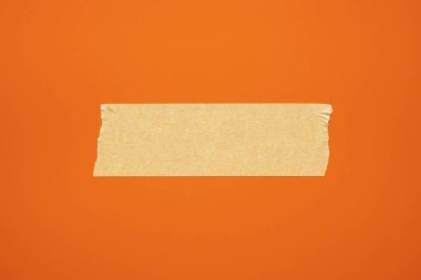 Kırmızı arka planda bej kağıt yapıştırıcı bant. Uzayı kopyala Yakın plan. Üst görünüm. 