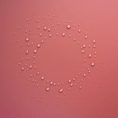 Pembe arka planda daire şeklinde su damlaları. Uzayı kopyala Üst Manzara. Yakın plan..