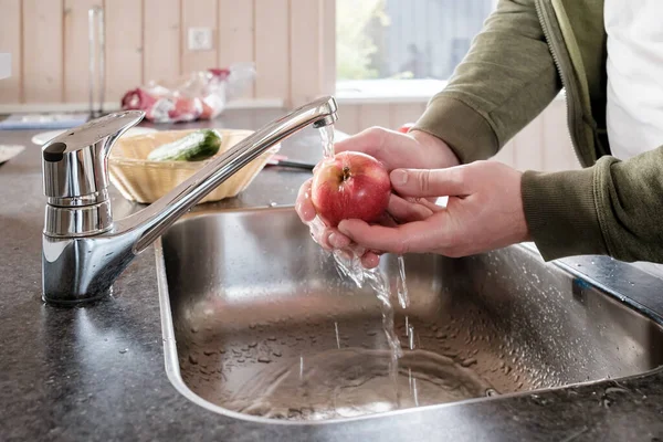 Mężczyzna Myje Dojrzałe Jabłko Pod Bieżącą Wodą Zlewie Kuchni Naturalnym — Zdjęcie stockowe