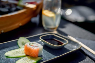 Appetizing sushi close-up. Maki and rolls with tuna, salmon, shrimp, crab and avocado. Top view of a variety of sushi on a dish.