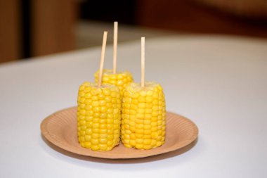 Three boiled corn close-up. Appetizing corn on a table in a cafe.