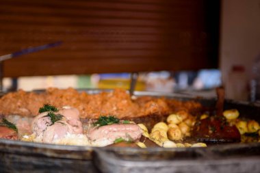 Cooking meat dishes in a summer restaurant on the street. Meat with greens close-up.