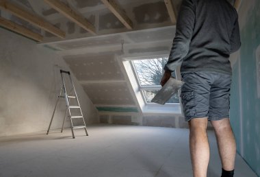 Özel bir evde alçıpan yapıştıran bir adam..