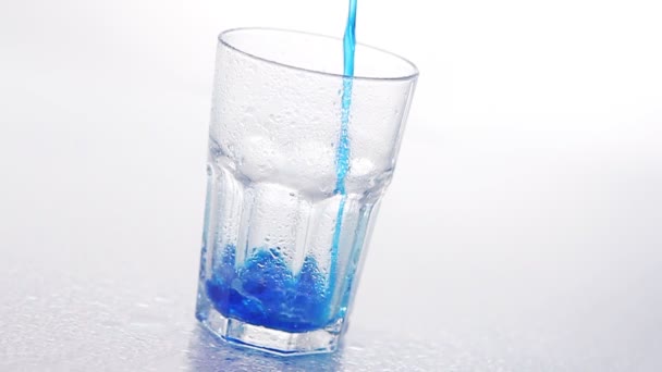 Синя рідина вливається в склянку — стокове відео