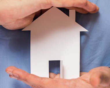 Kağıt ev onun elinde tutan adam