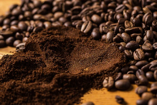 Grãos de café sobre a superfície de madeira — Fotografia de Stock