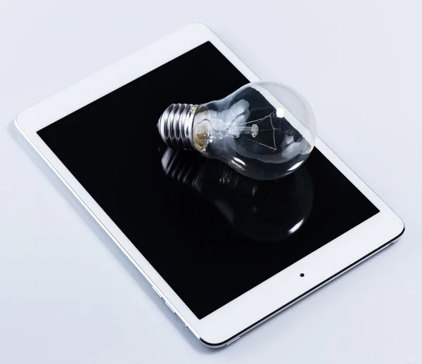 Light bulb and tablet pc — Stock Photo, Image