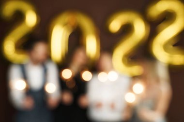 2022 yılını havai fişekler ve altın balonlarla kutlayan insanların odaklanmış görüntüsü.