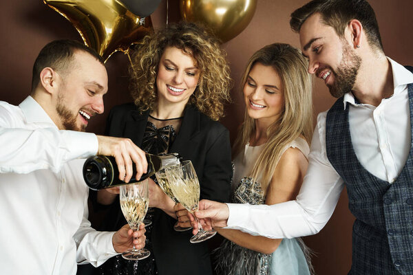 Group of beautiful well dressed party people celebrating  holiday or event and drinking sparkling wine