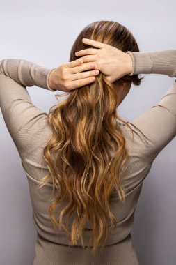 Genç bir kadın, profesyonel bir kuaförde boyama yaptıktan sonra güzel saçlarını gösteriyor.