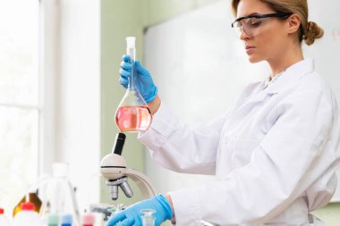 Bilim adamı araştırma sırasında mataranın içindeki maddeyi inceliyor..