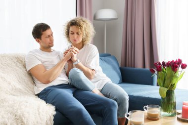 Genç ve mutlu bir çift kanepede oturuyor ve evde dinleniyor.