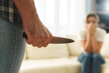Adam, kurbanına keskin bir bıçakla saldırıyor. Aile içi şiddet ya da seri cinayet kavramları.