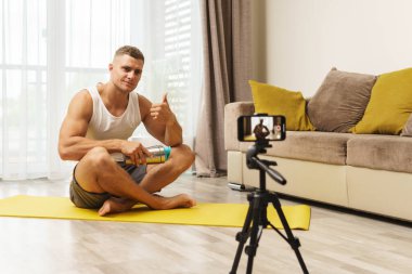 Evdeki fitness blogcusu aboneleri için video yayınlıyor veya kaydediyor