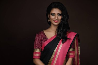 Geleneksel sari elbise giyen güzel bir Hintli kadının portresi.