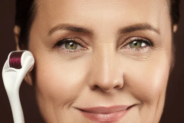 Penuaan Wanita Paruh Baya Menggunakan Mesoroller Untuk Kulit Wajahnya — Stok Foto