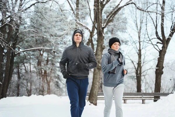 Sportowa Para Podczas Zimowego Joggingu Zaśnieżonym Parku Miejskim — Zdjęcie stockowe