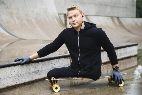 Young and motivated handicapped guy with a longboard in a skatepark