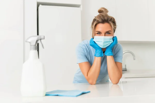 Young woman worker wearing prevention mask and gloves during apartment cleaning
