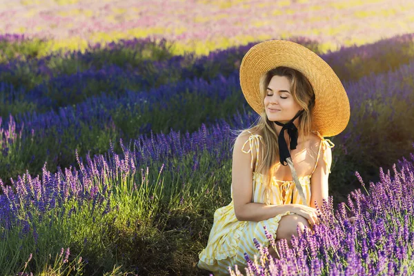 ラベンダーの花でいっぱいの分野で美しい若い女性の肖像画 — ストック写真