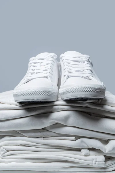 Montón Ropa Blanca Elegantes Zapatillas Deporte Sobre Fondo Gris — Foto de Stock