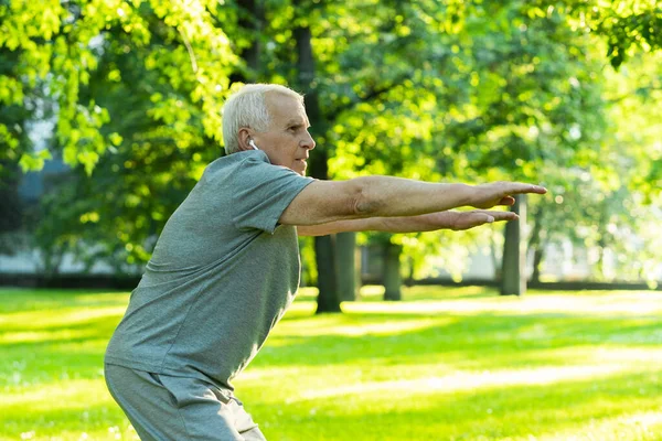 Aktywny Mężczyzna Podeszłym Wieku Ćwiczący Zielonym Parku Miejskim Podczas Treningu — Zdjęcie stockowe