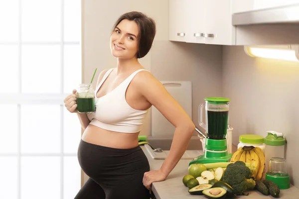 若いですと幸せな妊娠女性飲む健康緑スムージーで家 — ストック写真
