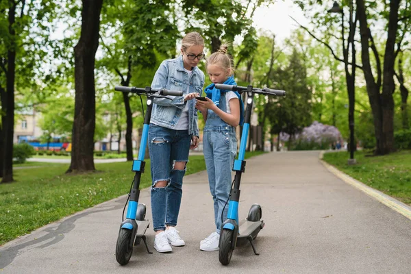 Mãe Filha Usando Aplicativo Smartphone Para Compartilhar Scooters Elétricos Parque — Fotografia de Stock