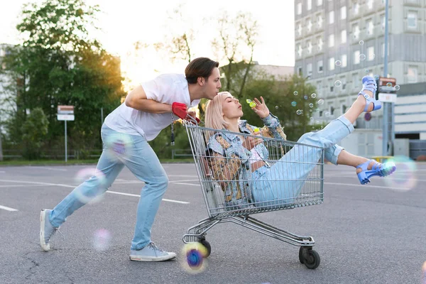 Šťastný Mladý Pár Bavte Nákupním Vozíkem Foukání Bubliny Parkovišti Supermarketu — Stock fotografie