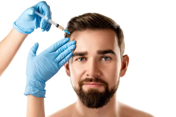 年轻英俊男子在白种人背景下接受面部注射以恢复肌肤活力 — 图库照片