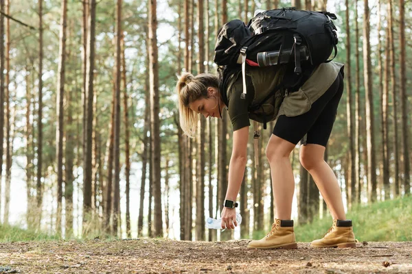Giovane Escursionista Donna Con Uno Zaino Che Raccoglie Rifiuti Plastica — Foto Stock