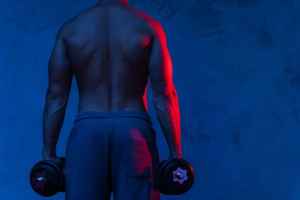 Giovane Muscoloso Bodybuilder Uomo Esercizio Con Manubri Luce Colorata Neon — Foto Stock