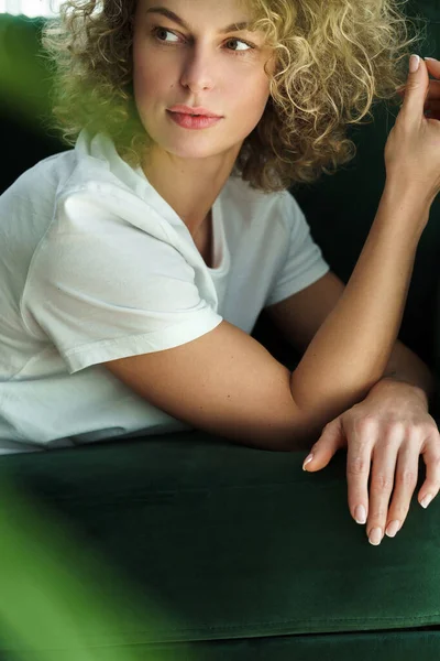 Yeşil Kanepede Yatan Kıvırcık Saçlı Genç Güzel Bir Kadının Portresi — Stok fotoğraf