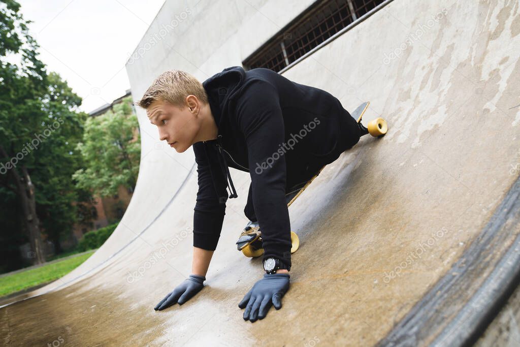Young and motivated handicapped guy with a longboard in a skatepark